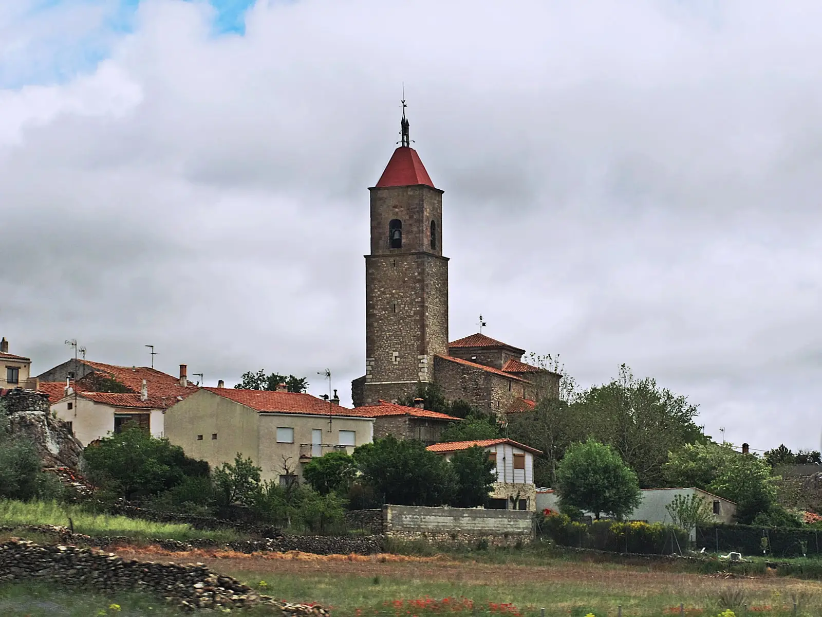 Nuestra Señora del Rosario parish church, with houses in Alcolea del Pinar.