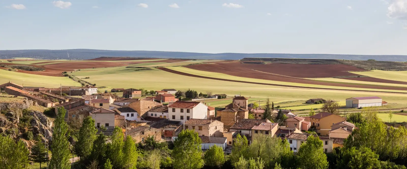 Panoramic view of Chera, with houses clustered below fields and hills.