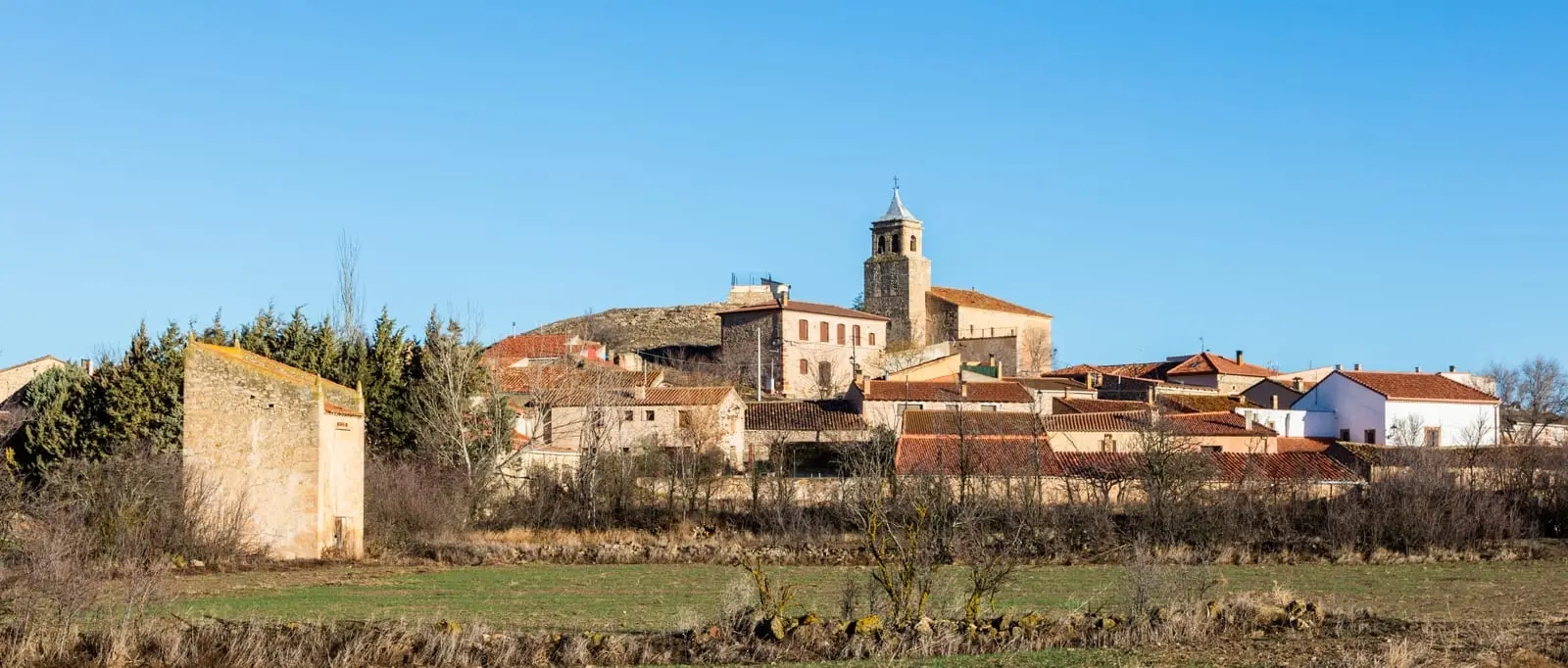 Panoramic view of Cillas, with the church and village houses on the hillside.