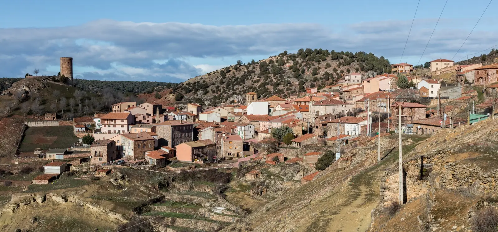 Panoramic view of Cobeta, Guadalajara, with houses and the castle tower on the hillside.