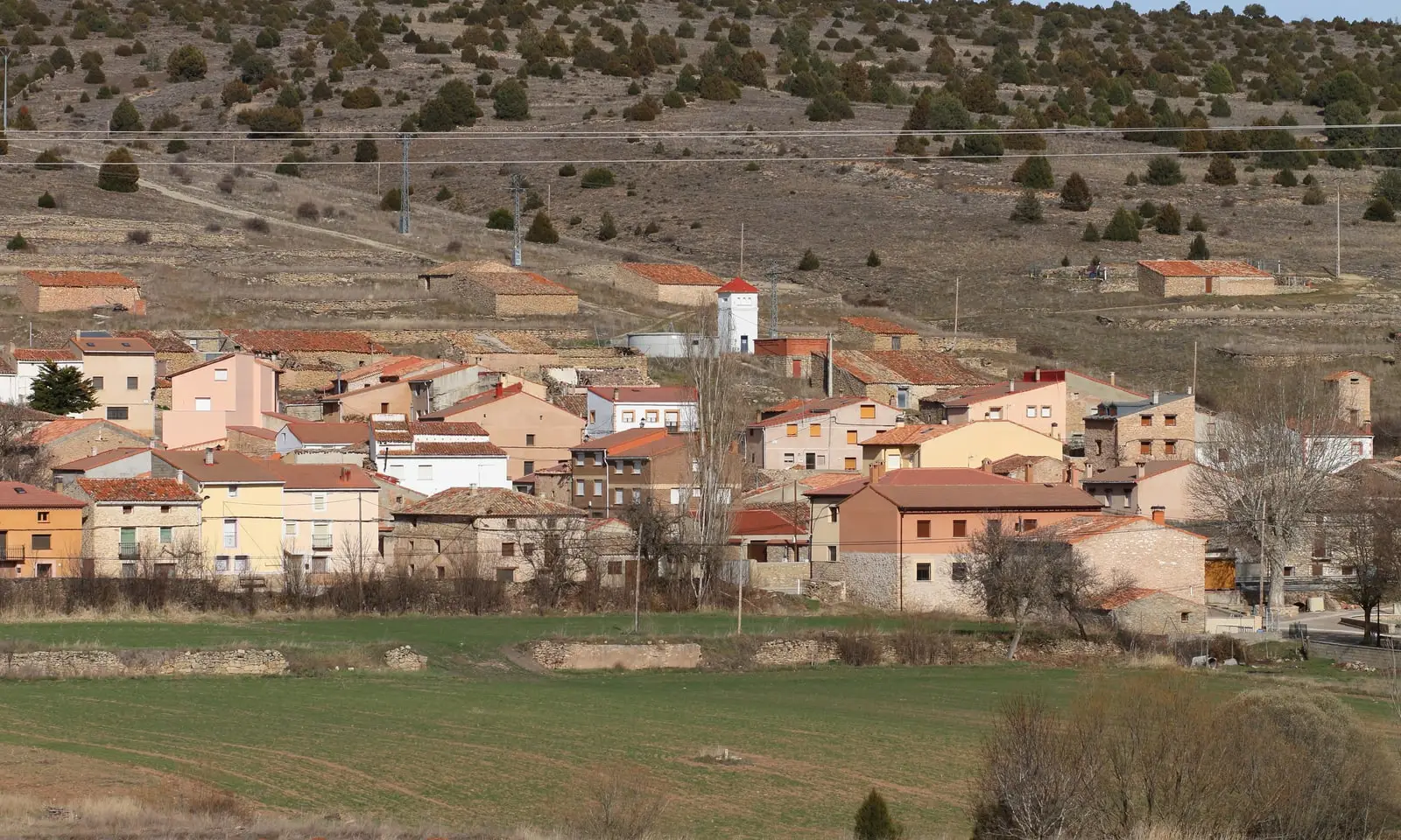 Panoramic view of Herrería, Guadalajara, with houses beside a rocky hillside.
