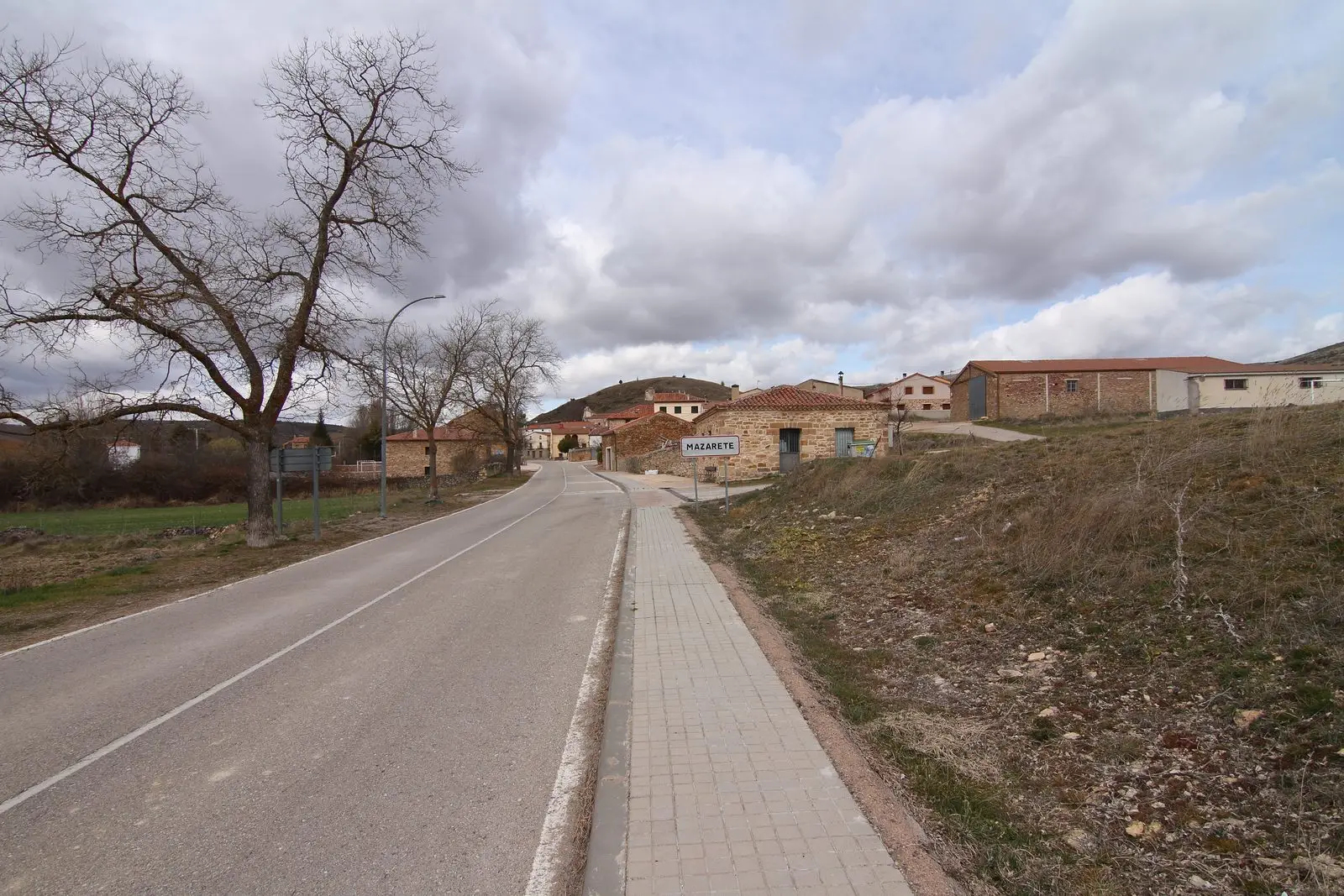 Entrance to Mazarete from the CM-2120, with the village sign and stone houses.