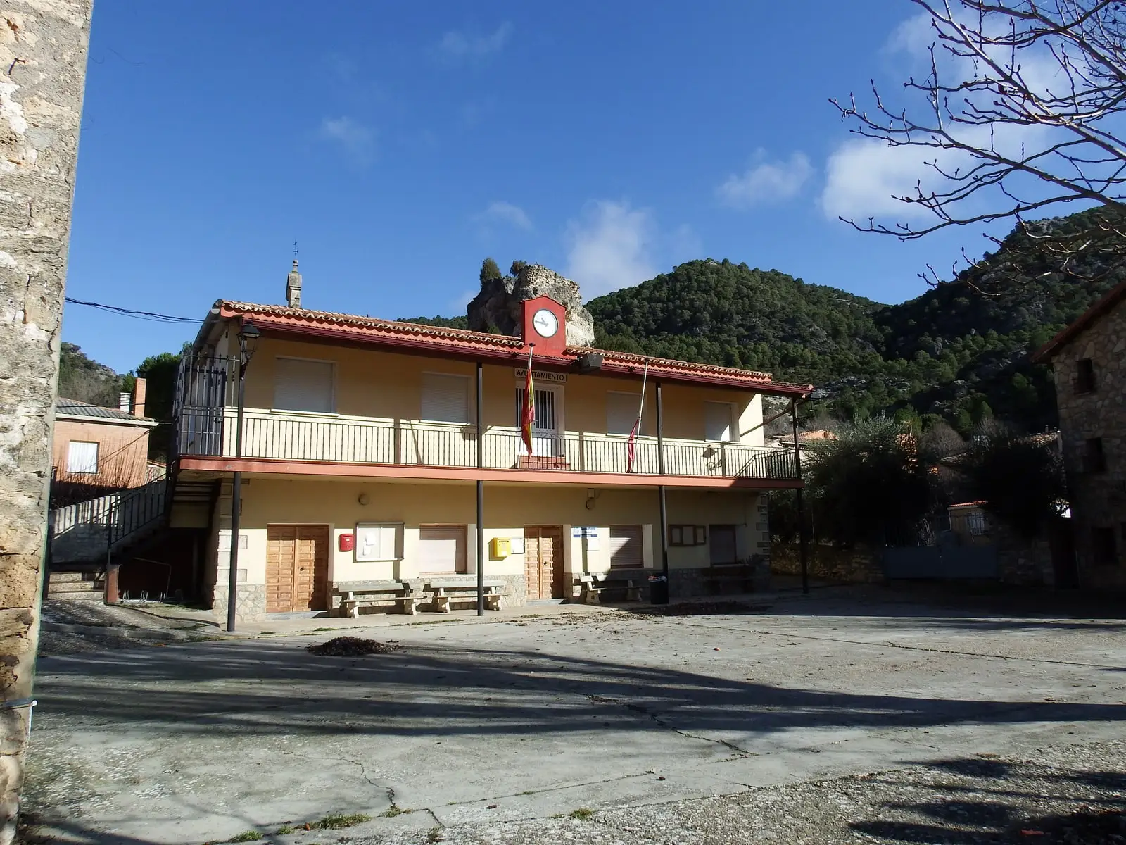 Ocentejo town hall, Guadalajara, in the village square, with rock and hillside behind.