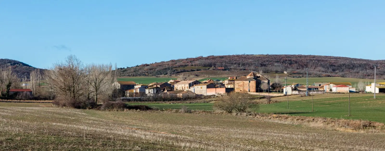 Panoramic view of Pardos with village houses among fields and hills.