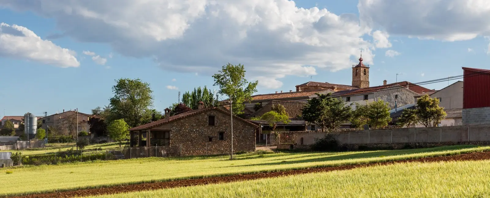 Prados Redondos with houses, cultivated fields and the church tower.