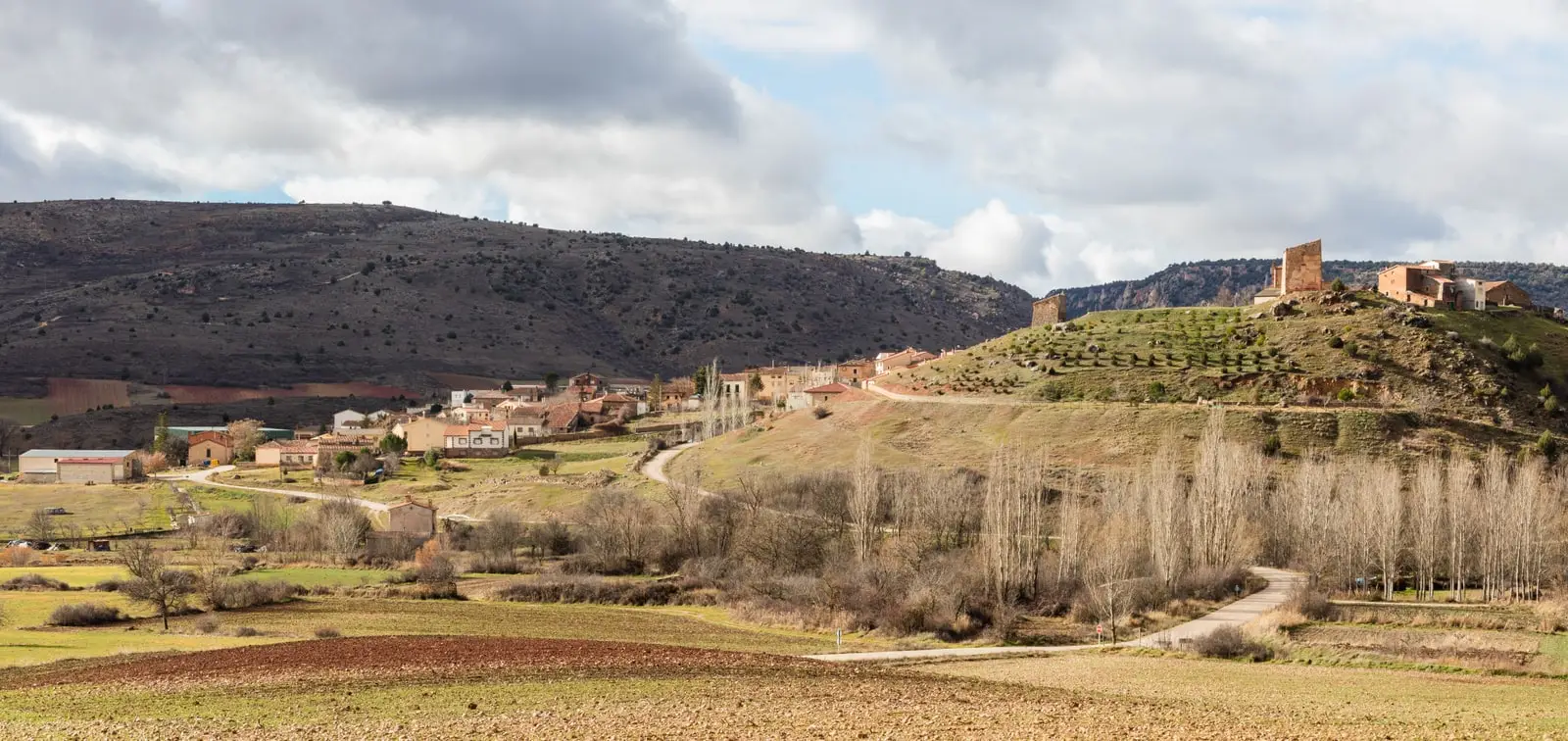 Panoramic view of Riba de Saelices beneath the tower and ruins on the hill.
