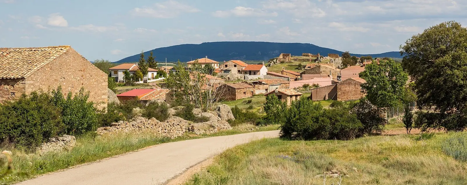 Rueda de la Sierra seen from a path, with its houses and church.