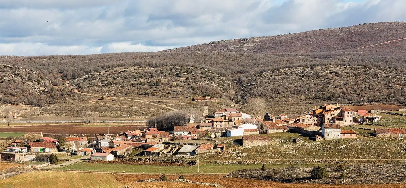 Panoramic view of Selas and its village houses among fields and hills.