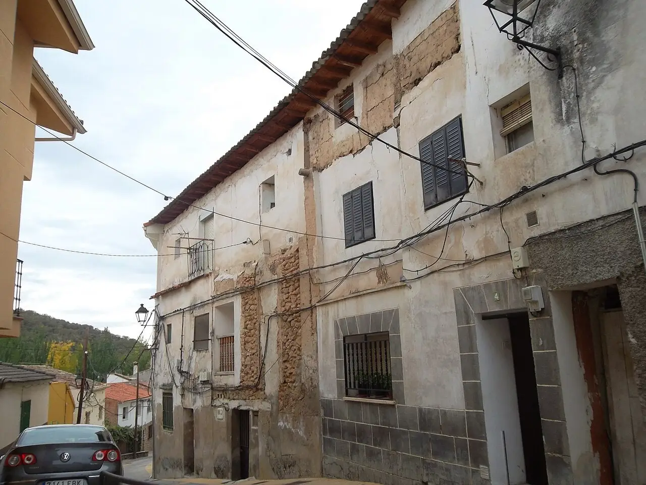 Street in Trillo lined with traditional houses, descending along the hillside.